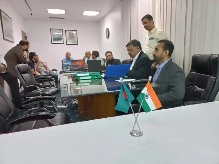 Representatives working around a table with Bangladesh and India desk flags