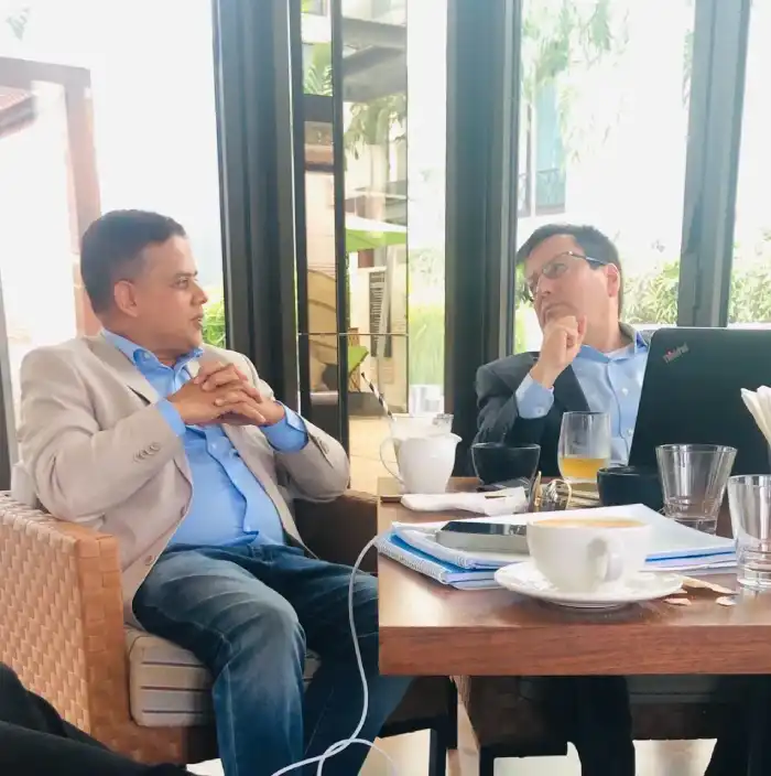 Two business representatives discussing documents at a table