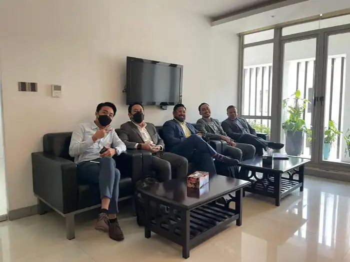Five colleagues seated together in an office waiting area