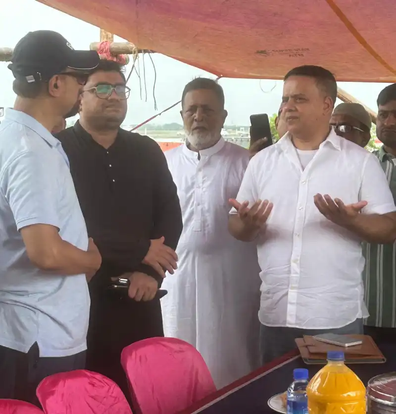 Team members discussing site plans under a canopy