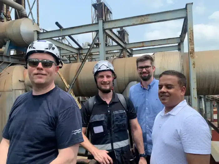 Visitors wearing safety helmets at an industrial facility