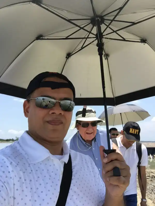 Team members under umbrellas during a field visit