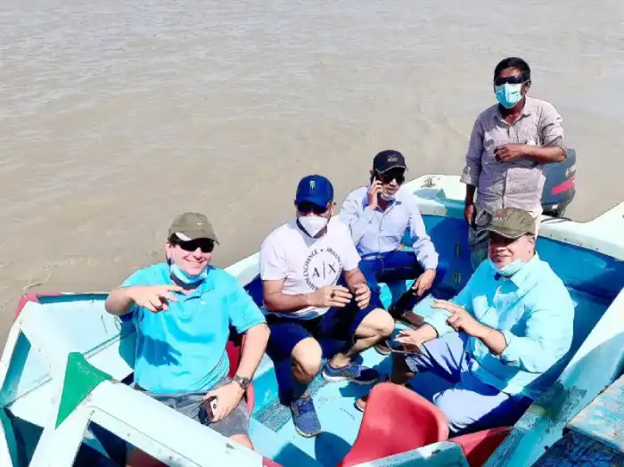 Five team members seated in a blue boat