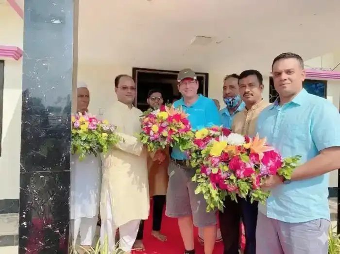 Colleagues welcoming a visitor with flowers