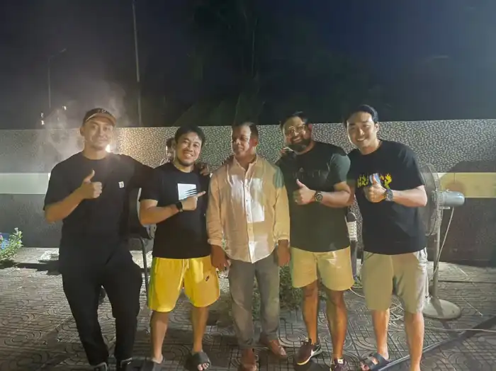 Five colleagues posing together outdoors at night