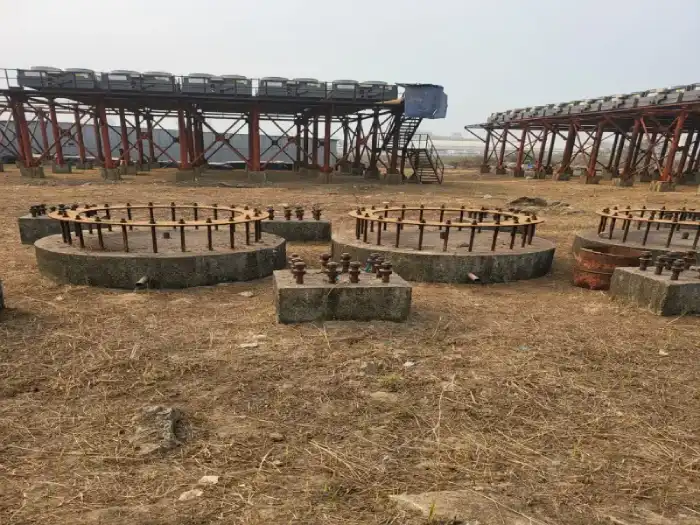 Circular concrete foundations and elevated industrial structures at a project site