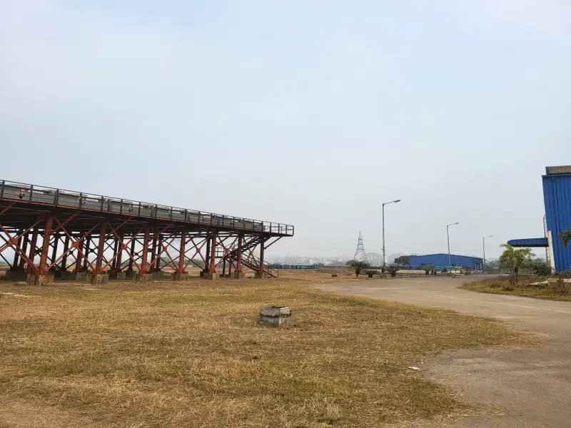 Elevated steel structure beside a road and industrial buildings